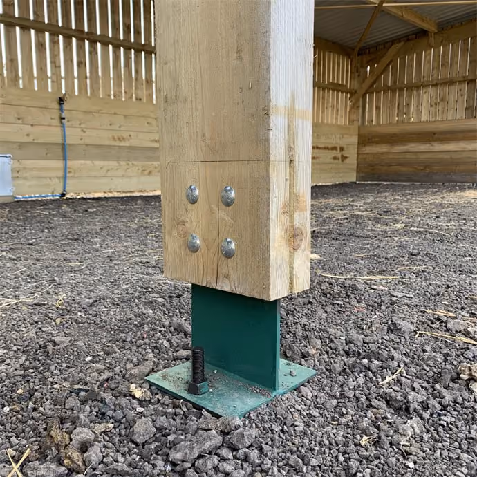 Steel footing supporting a timber-framed barn